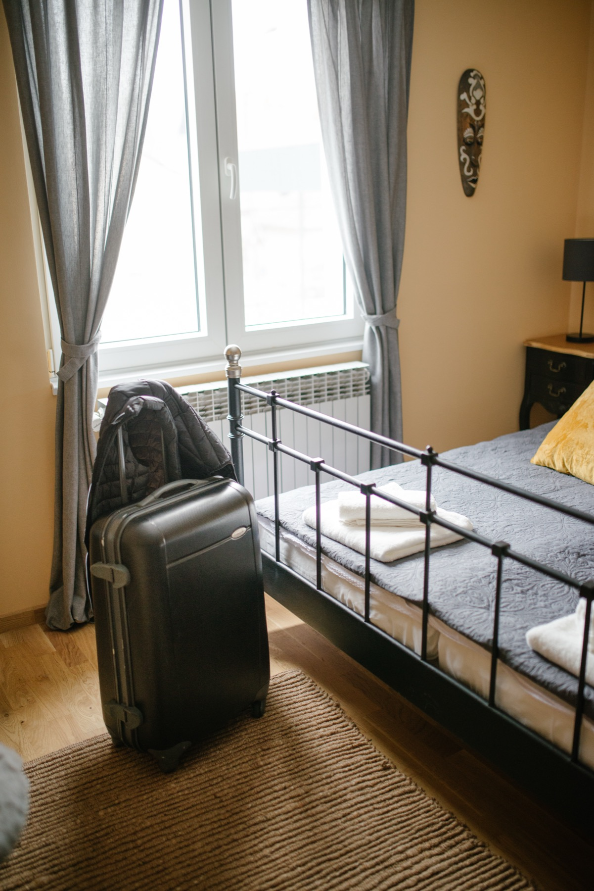 Suitcase beside a bed in temporary housing for a travel therapy assignment